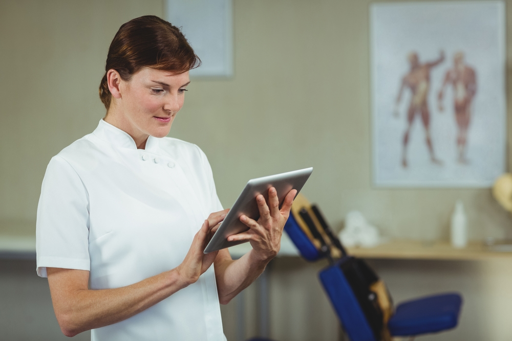 Fisioterapeuta usando tablet digital na clínica