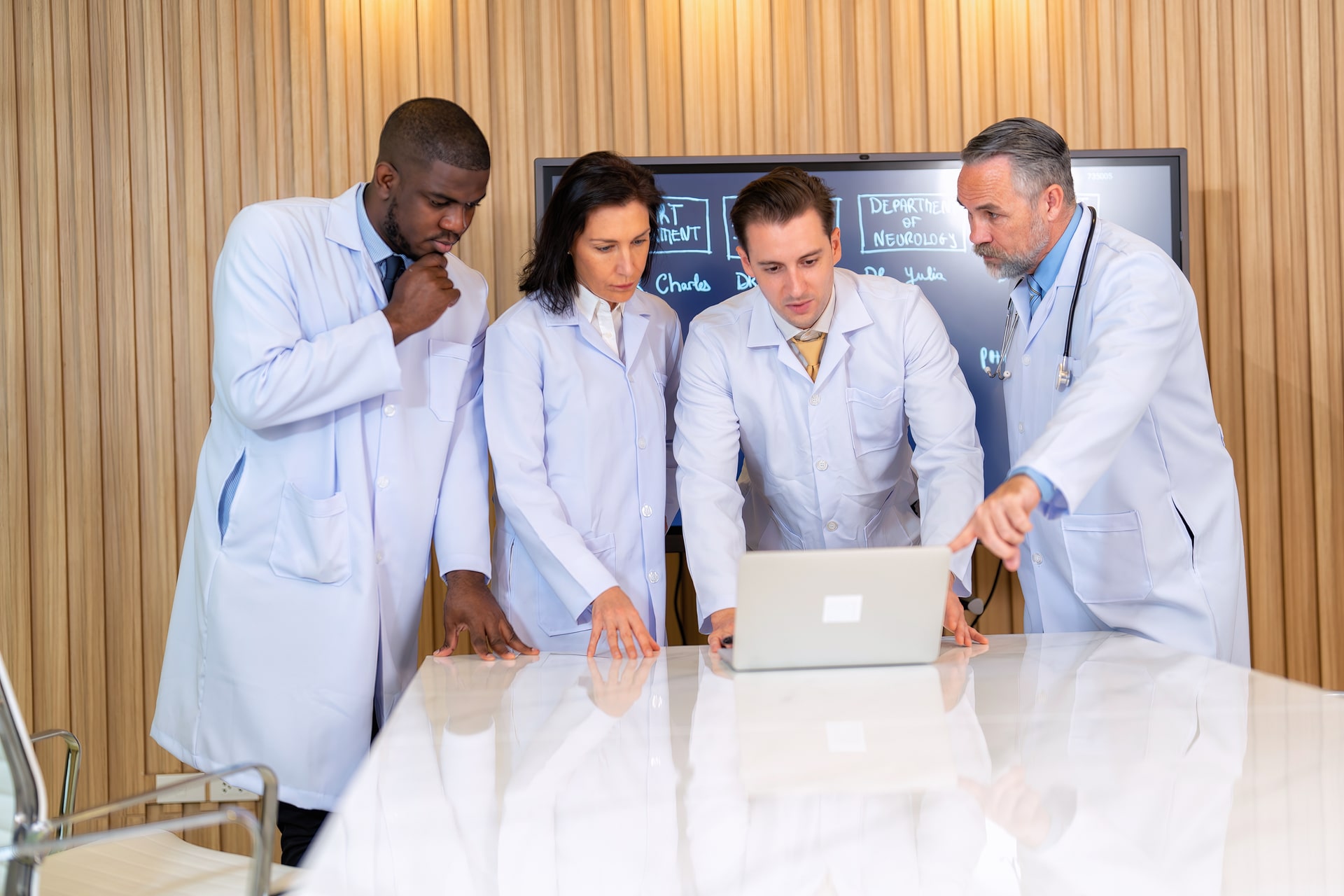 Um grupo de médicos na sala de reunião, olhando o resultado no notebook